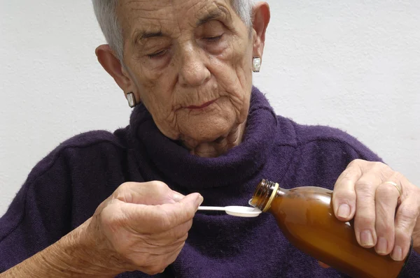 Mujer mayor que toma jarabe — Foto de Stock