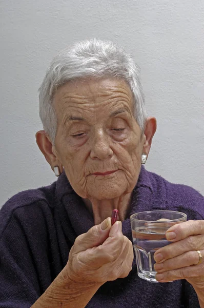 Старша жінка приймає таблетки — стокове фото