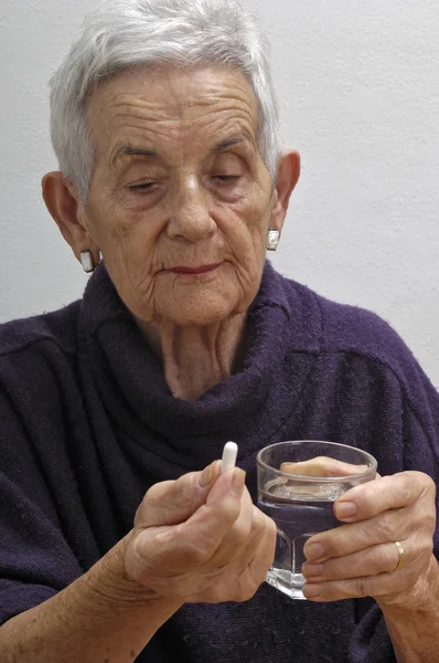 Mujer mayor tomando pastillas — Foto de Stock