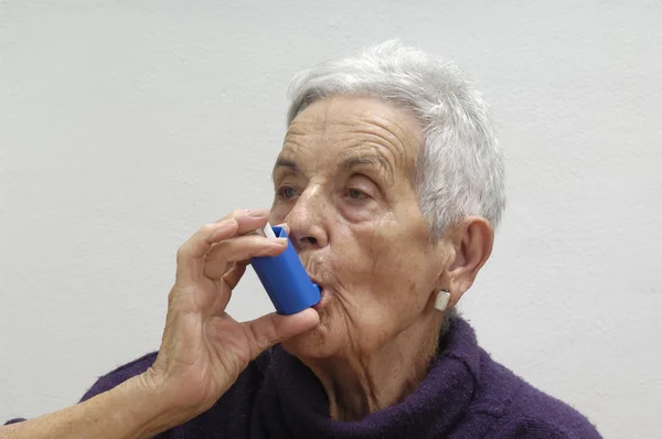 Oude vrouw met een inhaleertoestel — Stockfoto