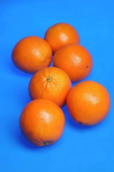 Апельсини на синьому фоні — стокове фото
