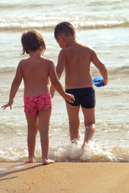 Küçük erkek ve kız deniz izlerken elele