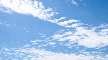 Yazın son günlerinde rüzgarla gökyüzünde savrulan beyaz bulutlar. Güzel, temiz gökyüzü arkaplan fotoğrafı.