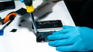 Akıllı telefon dahili devre kartı üzerinde çalışan tamir aracını kapat.