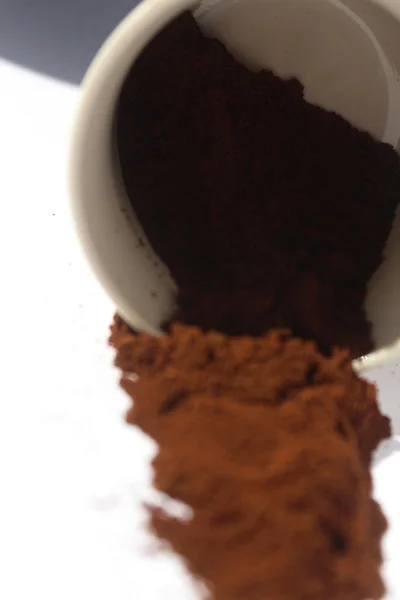 Caída taza de café llena de tierra sobre un fondo blanco — Foto de Stock