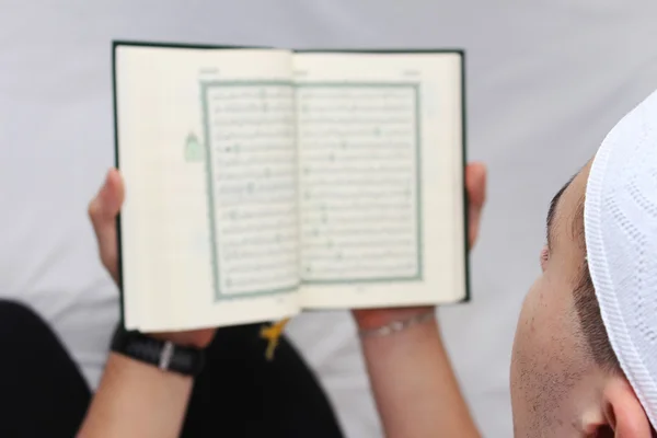 Muslimský muž čtení islámské svaté knihy Koránu — Stock fotografie