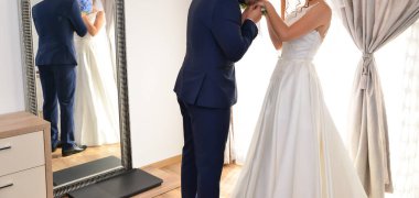 Gelin ve damat birlikte mavi bir çiçek buketi tutuyorlar.