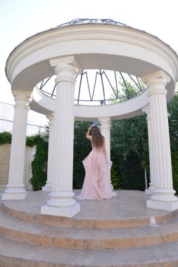 Pembe uzun elbiseli manken fotoğraf çekimi yapıyor.