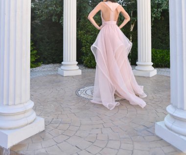 Pembe uzun elbiseli manken fotoğraf çekimi yapıyor.