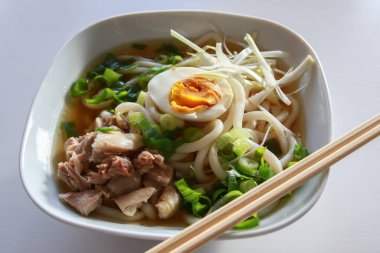 Beyaz arka planda yumurtalı Ramen Asya eriştesi.
