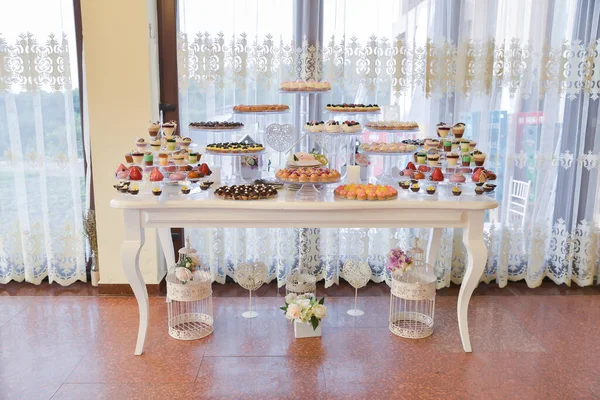 sweets and cookies arranged on the table for wedding reception