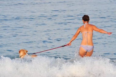 Kadın ve köpek deniz dalgalarında