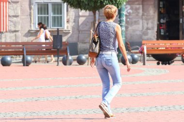  İnsanlar güneşli bir günde sokakta yürüyorlar.