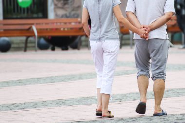 İnsanlar güneşli bir günde sokakta yürüyorlar.