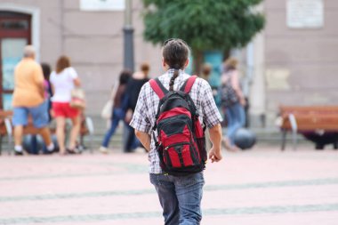 İnsanlar güneşli bir günde sokakta yürüyorlar.