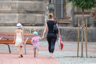 İnsanlar güneşli bir günde sokakta yürüyorlar.