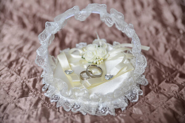 wedding rings in a white basket