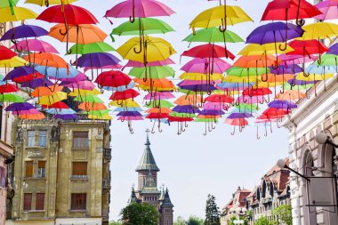 Şehir sokaklarında asılı renkli şemsiye