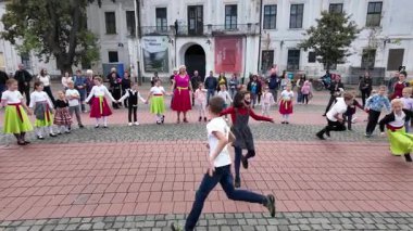 Timisoara, Romanya, 27 Eylül 2025, Çocuklar daire şeklinde dans ediyor ve Timisoara Macar Kültür Günleri festivalinde mutlu bir şekilde oynuyorlar.