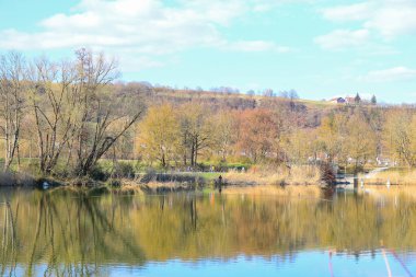 Regenburg, Almanya, 27 Mart 2022: İnsanlar güzel Regensburg ilkbahar doğasında göl kenarındaki manzaralı kırsal bir yolda yürüyüp dinleniyorlar