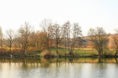 Regenburg, Almanya, 26 Mart 2022: İnsanlar güzel Regensburg ilkbahar doğasında göl kenarındaki manzaralı kırsal bir yolda yürüyüp dinleniyorlar