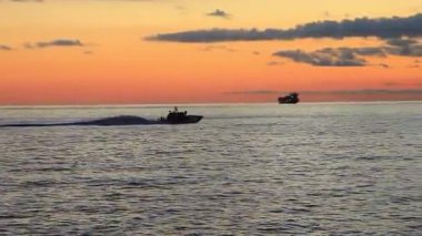 Günbatımı motorlu tekne silueti Bogliasco İtalya yakınlarındaki Ligurian okyanusunda ilerliyor.