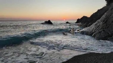 Bogliasco İtalya 'da sakin okyanus dalgaları ve kumlu kıyılar üzerinde sakin gün batımı