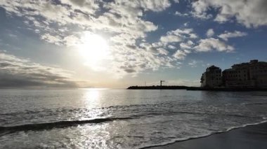 Yumuşak dalgalar, kışın sahil köyü Bogliasco 'da kumlu plajlara ağır çekim 120 fps hızla akıyor.