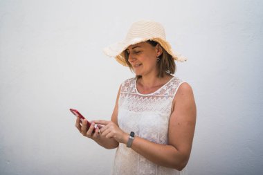 Telefonunu ve kulaklığını şapka takan bir kadın.