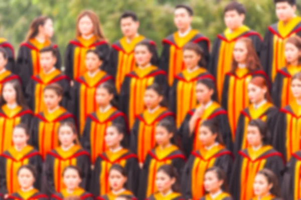 Rozmazané absolventů stojí na stánku fandit. — Stock fotografie