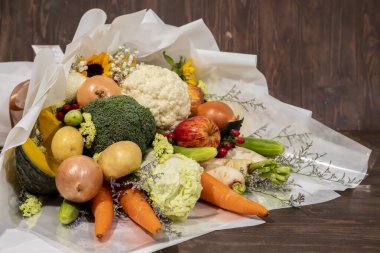 Bir demet çiçek sebze, soğan, havuç, elma, balkabağı, lahana, patates içerir.