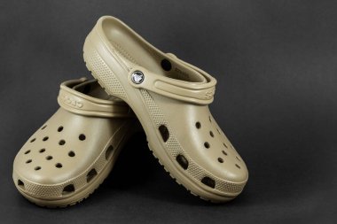 Bangkok, Tayland - 12 Ağustos 2018: Siyah zemin üzerinde motif tasarımlı bir çift kahverengi Crocs sandaleti.