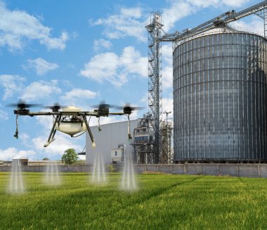 Arka planda tarımsal silolarla yeşil pirinç tarlalarında uçan tarım aracı..