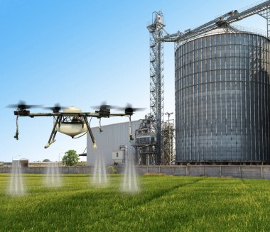 Arka planda tarımsal silolarla yeşil pirinç tarlalarında uçan tarım aracı..