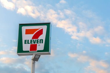 Bangkok, Tayland - 9 Aralık 2025: 7-Eleven mağaza tabelası mavi gökyüzü arka planında. 7-Eleven dünyanın en büyük market bayiliği..