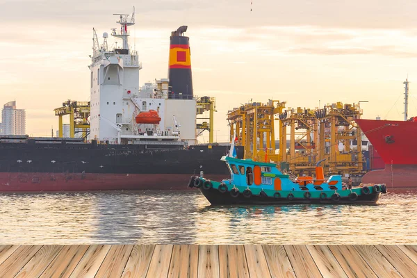 Рибальські судна біля контейнерних вантажних вантажних суден силует в — стокове фото