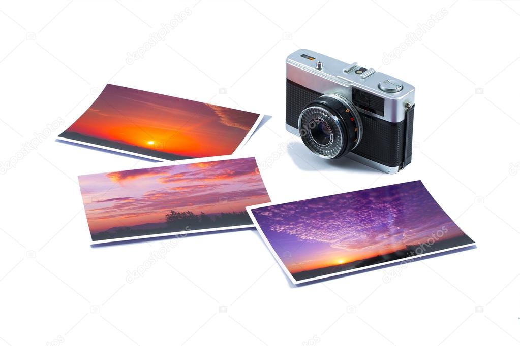 Old SLR camera with photo prints isolated on white background