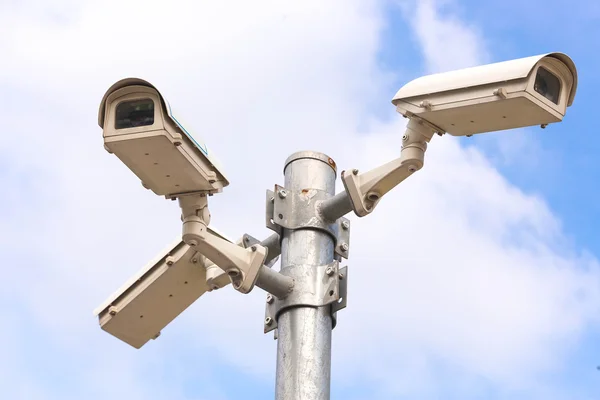 Three security cameras against blue sky — Stock Photo, Image