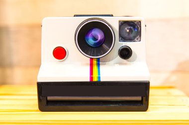 Anlık fotoğraf makinesi veya Polaroid arazi üzerinde ahşap masa izole kamera.