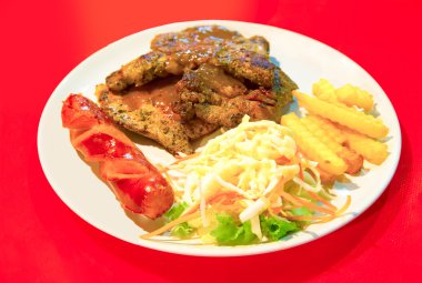 Grilled Porkchop Steak with salad, Smoked Sausage and French Fri