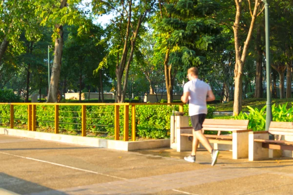 Rozostřit obraz lidí, běh, chůze, jogging v parku s bokeh — Stock fotografie