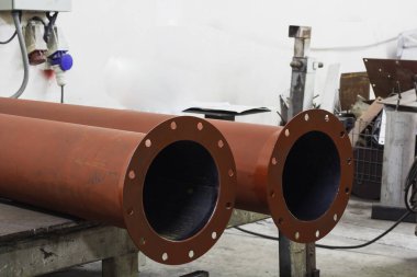 Fabrikadaki paslanmaz boyalı çelik borular. Kırmızı demir boru.