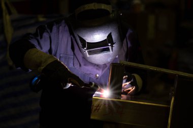 Metal işçileri amelelik, becerikli kaynakçılık, fabrika işçileri OT yapıyor. Kaynakçı fabrikadaki çeliği kaynaklıyor..