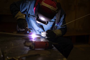Metal işçileri amelelik, becerikli kaynakçılık, fabrika işçileri OT yapıyor. Kaynakçı fabrikadaki çeliği kaynaklıyor..