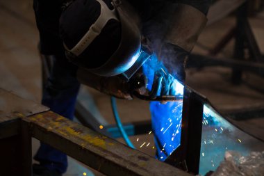 Metal işçileri amelelik, becerikli kaynakçılık, fabrika işçileri OT yapıyor. Kaynakçı fabrikadaki çeliği kaynaklıyor..