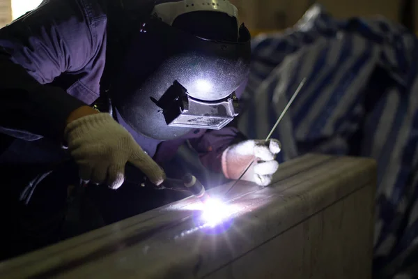 Metal workers use manual labor, Skilled welder, Factory workers making OT. Welder is welding the steel in the factory.