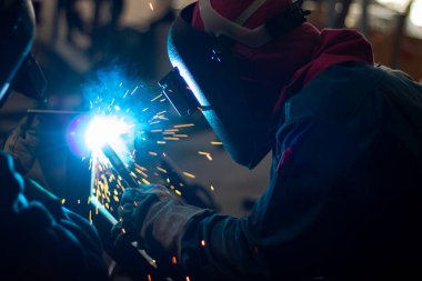 Metal işçileri amelelik, becerikli kaynakçılık, fabrika işçileri OT yapıyor. Kaynakçı fabrikadaki çeliği kaynaklıyor..