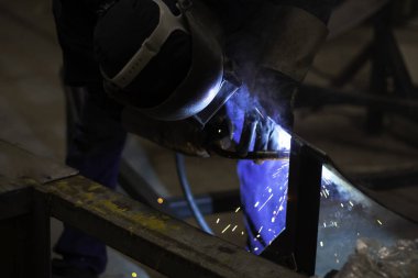 Metal işçileri amelelik, becerikli kaynakçılık, fabrika işçileri OT yapıyor. Kaynakçı fabrikadaki çeliği kaynaklıyor..