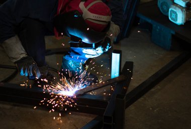 Metal işçileri amelelik, becerikli kaynakçılık, fabrika işçileri OT yapıyor. Kaynakçı fabrikadaki çeliği kaynaklıyor..