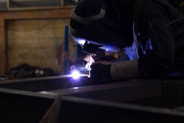 Metal işçileri amelelik, becerikli kaynakçılık, fabrika işçileri OT yapıyor. Kaynakçı fabrikadaki çeliği kaynaklıyor..